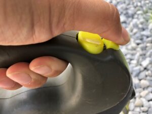 Blick von der Seite auf eine Flexileine mit dem Daumen auf der Arretierung